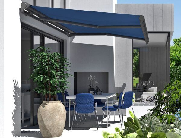 Eine blaue Markise über einer Terrasse mit Gartenmöbeln.