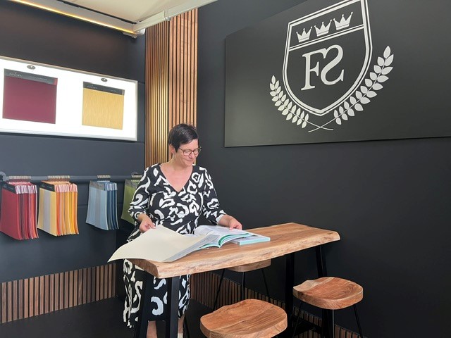 Hausfassade mit elektrisch steuerbarer Gelenkarmmarkise und stilvoller Stoffbespannung